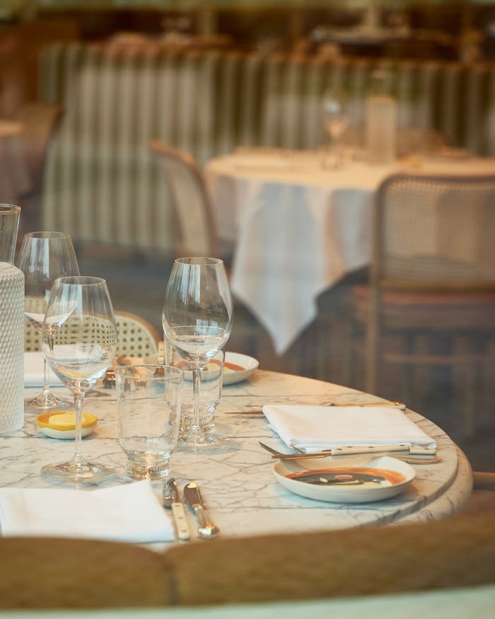 A beautifully set dining table with glassware and cutlery in a cozy restaurant atmosphere.